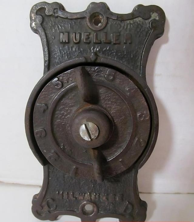 A historic and iconic piece used to regulate heat in early 20th-century homes, marked with the “Mueller” name and numbered dial.